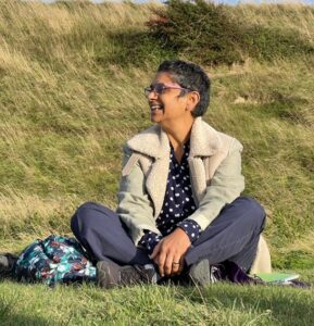 Razia sitting cross legged on the downs.